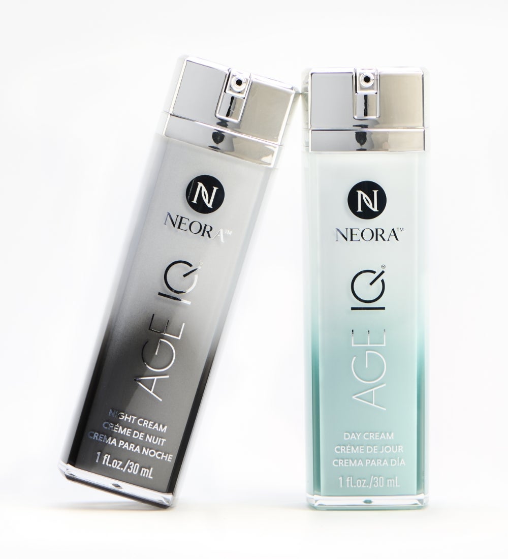 A man with face cream on his under-eye holds up a bottle of Age IQ Night Cream to his neck and shoulder.